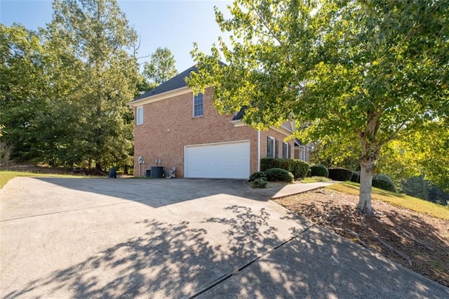 view of property exterior with cooling unit and a garage