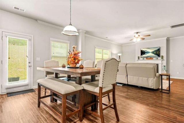 dining room with ornamental molding and wood finished floors