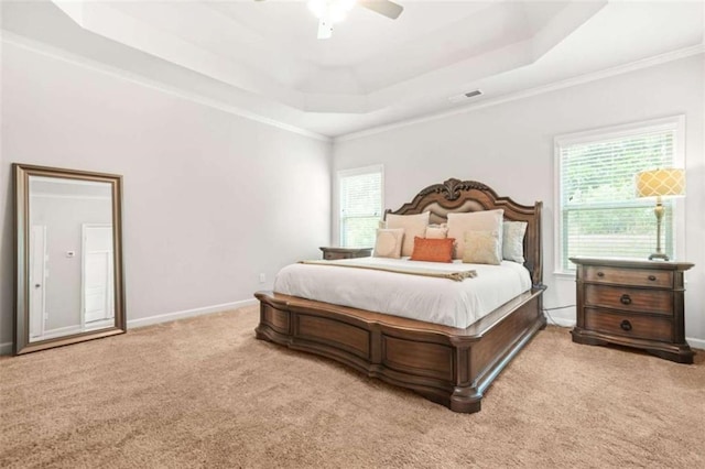 bedroom featuring multiple windows, baseboards, a tray ceiling, and carpet floors