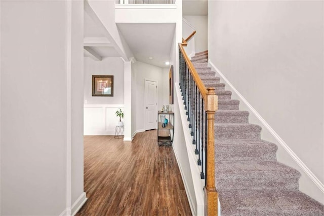 stairway with wood finished floors, recessed lighting, and baseboards