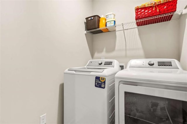 washroom with washing machine and clothes dryer and laundry area