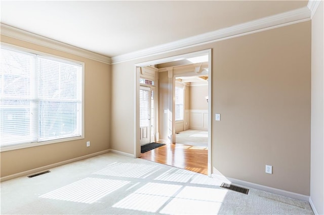 unfurnished room with crown molding and light colored carpet