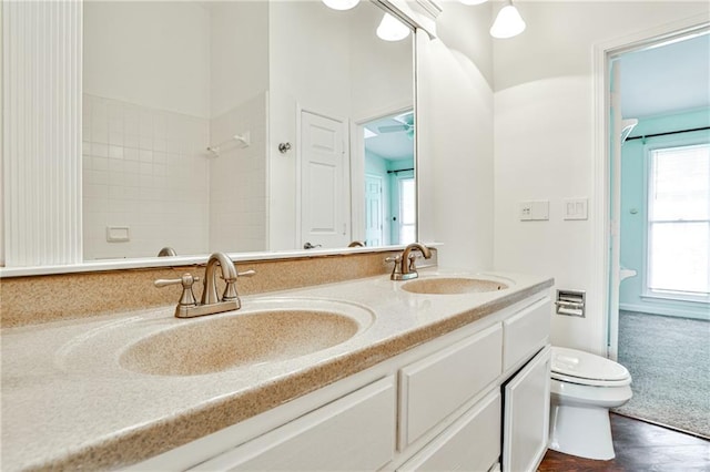 bathroom with vanity, toilet, and hardwood / wood-style flooring