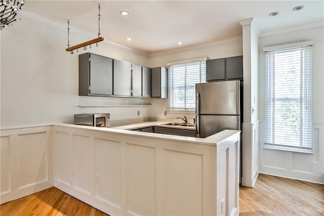 kitchen featuring stainless steel fridge, gray cabinetry, and plenty of natural light