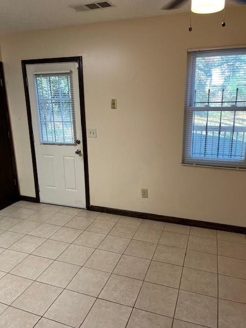 entrance foyer featuring plenty of natural light, ceiling fan, and light tile patterned floors