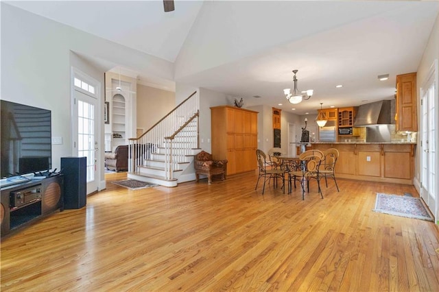 dining space with light hardwood / wood-style floors, a chandelier, lofted ceiling, and french doors