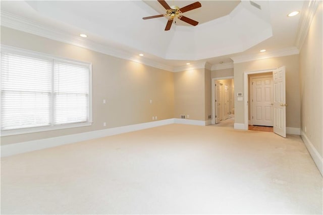 interior space with ceiling fan, crown molding, light carpet, and a raised ceiling