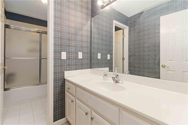 bathroom featuring bath / shower combo with glass door, tile patterned floors, and vanity