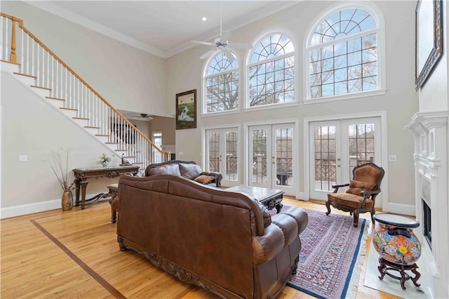 living room featuring a premium fireplace, ceiling fan, french doors, and crown molding