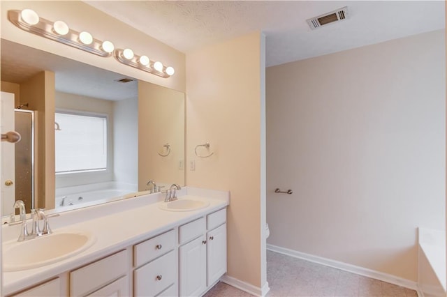 bathroom featuring a bath, visible vents, and a sink