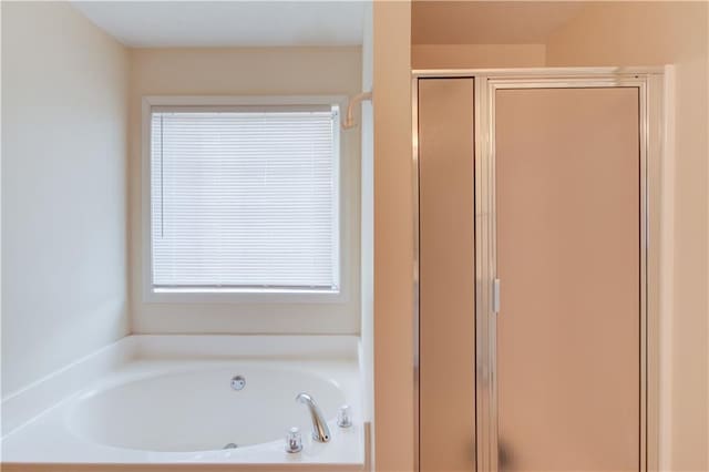 bathroom featuring a stall shower and a garden tub