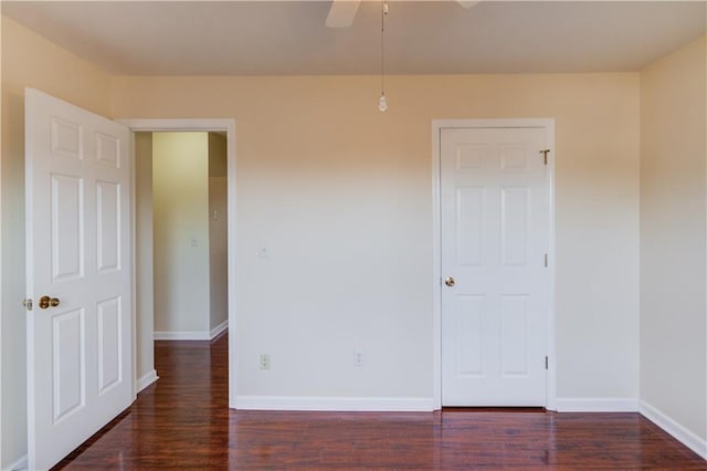 empty room featuring dark wood finished floors and baseboards