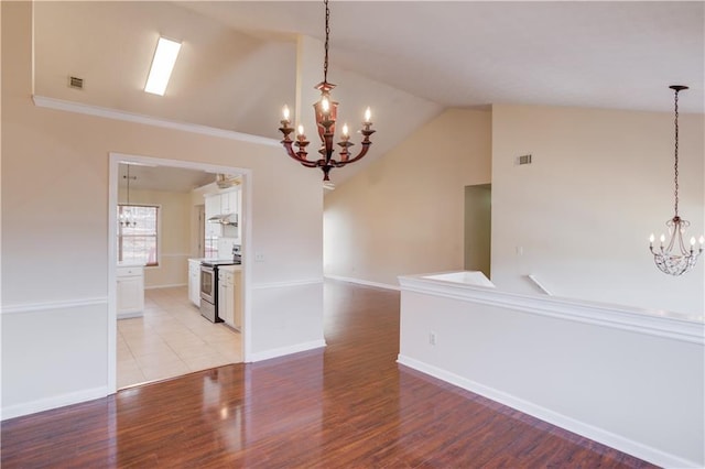 empty room with light wood-style floors, visible vents, a chandelier, and vaulted ceiling