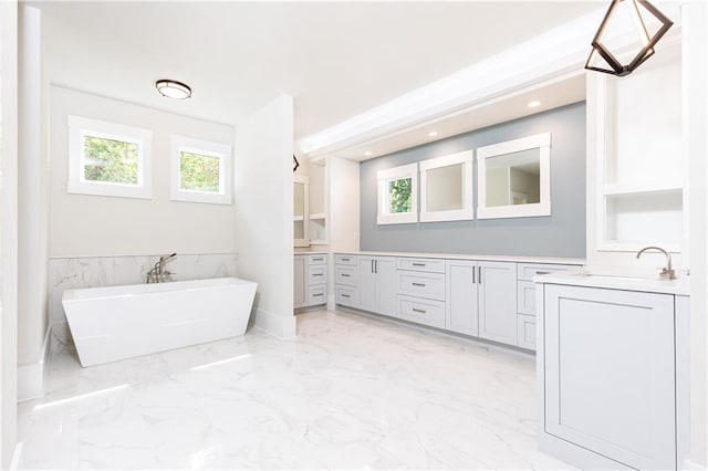 bathroom with vanity, built in shelves, and a tub