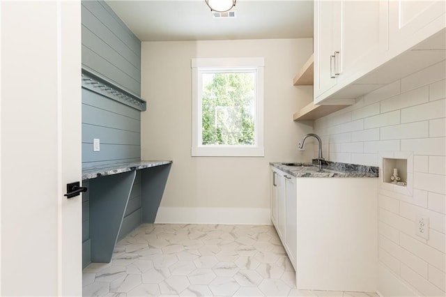 laundry area with cabinets, hookup for a washing machine, sink, and light tile patterned floors