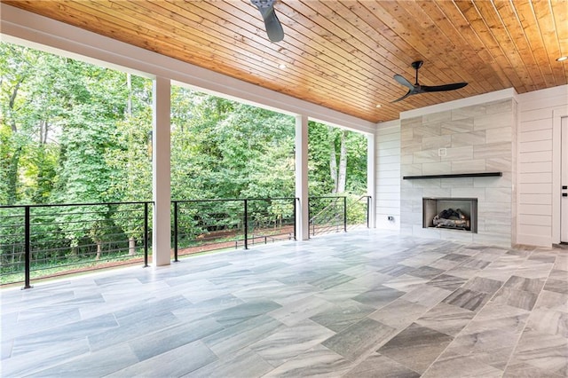 view of patio with ceiling fan and a fireplace