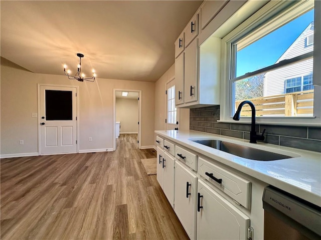 kitchen featuring tasteful backsplash, sink, decorative light fixtures, dishwasher, and white cabinets