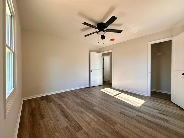 unfurnished bedroom featuring ceiling fan, dark wood-type flooring, and a closet