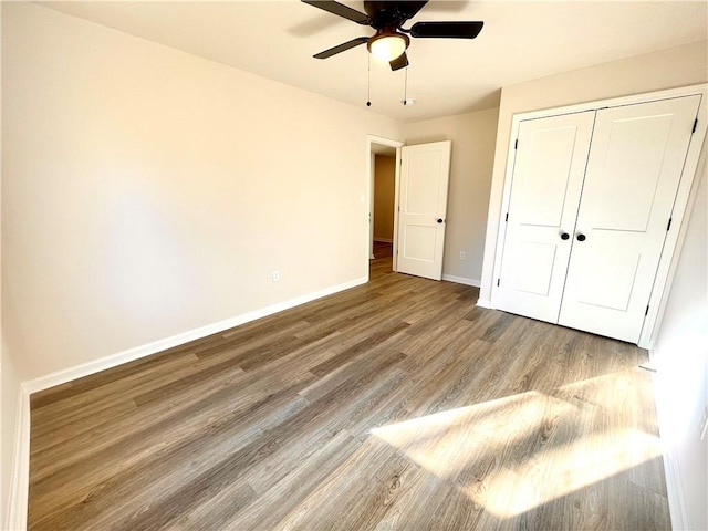 unfurnished bedroom with hardwood / wood-style floors, ceiling fan, and a closet