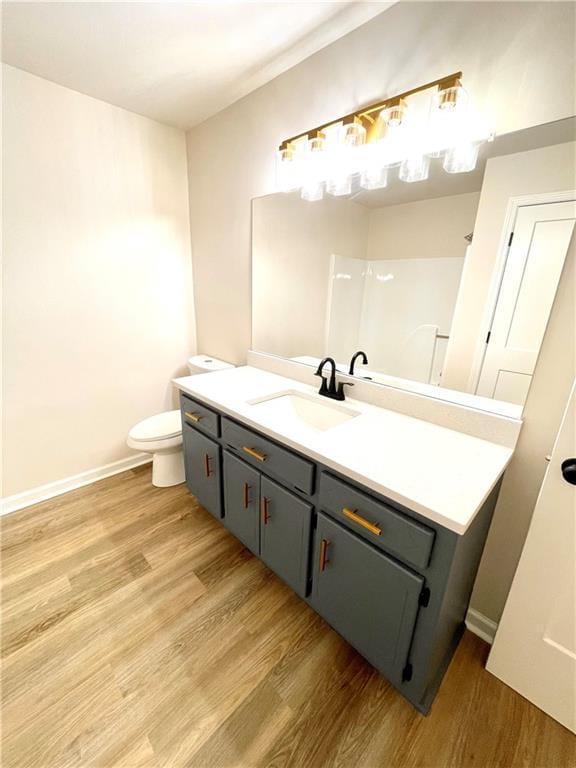 bathroom featuring vanity, wood-type flooring, and toilet