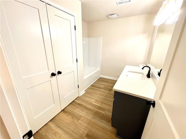 bathroom with shower / bathing tub combination, vanity, and hardwood / wood-style flooring