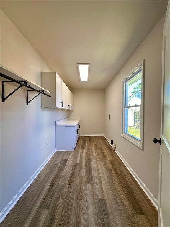 laundry room featuring cabinets and dark wood-type flooring