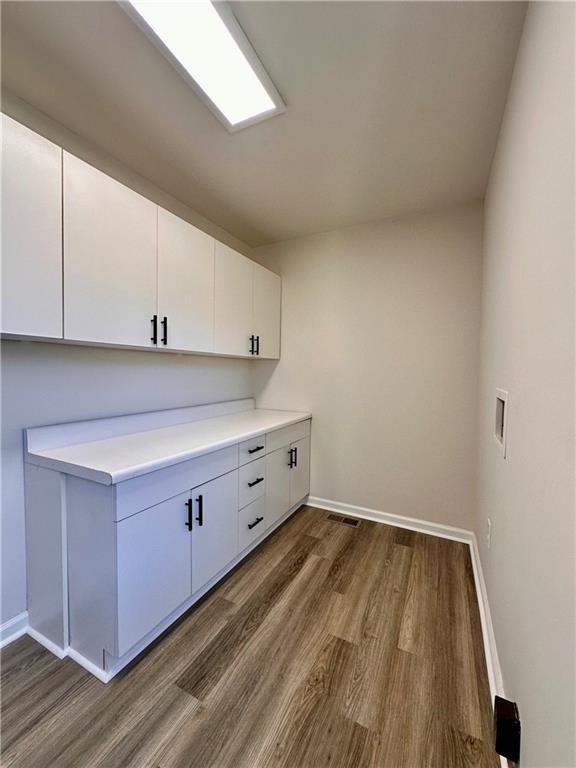 washroom with dark hardwood / wood-style flooring, cabinets, and washer hookup