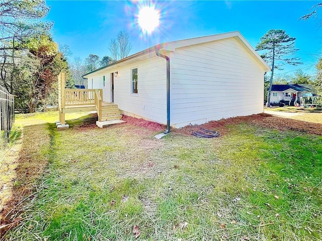 view of home's exterior featuring a deck and a lawn