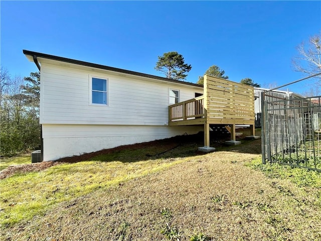 exterior space featuring central air condition unit, a yard, and a deck