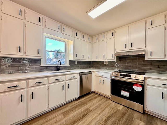 kitchen featuring stainless steel appliances, white cabinetry, and sink