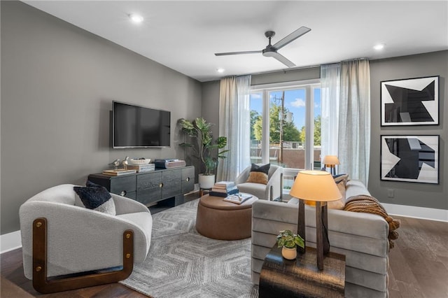 living room featuring ceiling fan and dark wood-type flooring