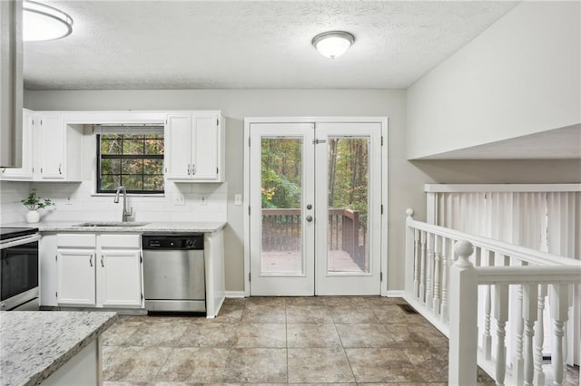 kitchen featuring a wealth of natural light, sink, white cabinets, and appliances with stainless steel finishes