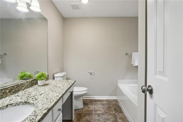 bathroom featuring vanity, toilet, and a washtub