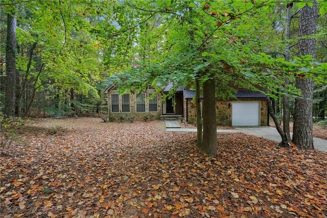 view of property hidden behind natural elements featuring a garage