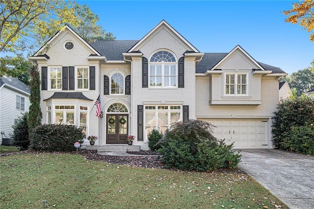 view of front of house with a garage, a front lawn, and french doors