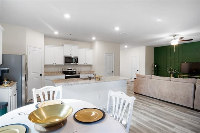 217 Limestone Cir, Conyers, GA 30013 - kitchen featuring stainless steel appliances, open floor plan, white cabinets, a sink, and an island with sink