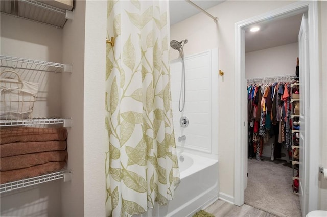 217 Limestone Cir, Conyers, GA 30013 - full bath featuring wood finished floors, shower / bath combo with shower curtain, a spacious closet, and baseboards