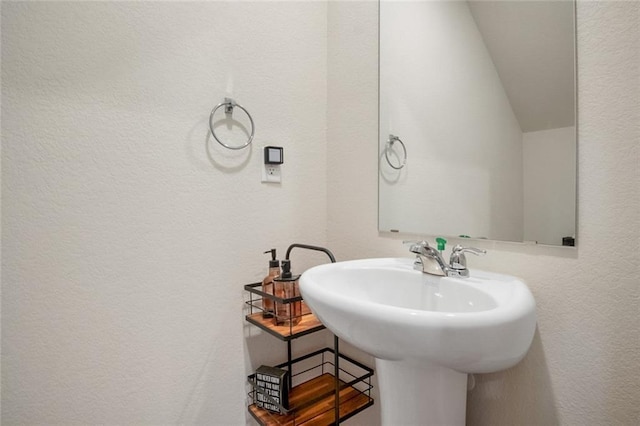 217 Limestone Cir, Conyers, GA 30013 - bathroom featuring a textured wall, a sink, and lofted ceiling