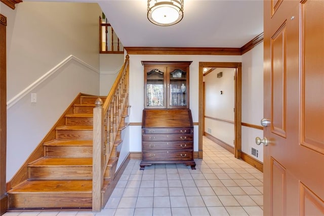 stairs with baseboards, ornamental molding, visible vents, and tile patterned floors