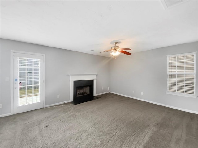 unfurnished living room featuring carpet flooring and ceiling fan