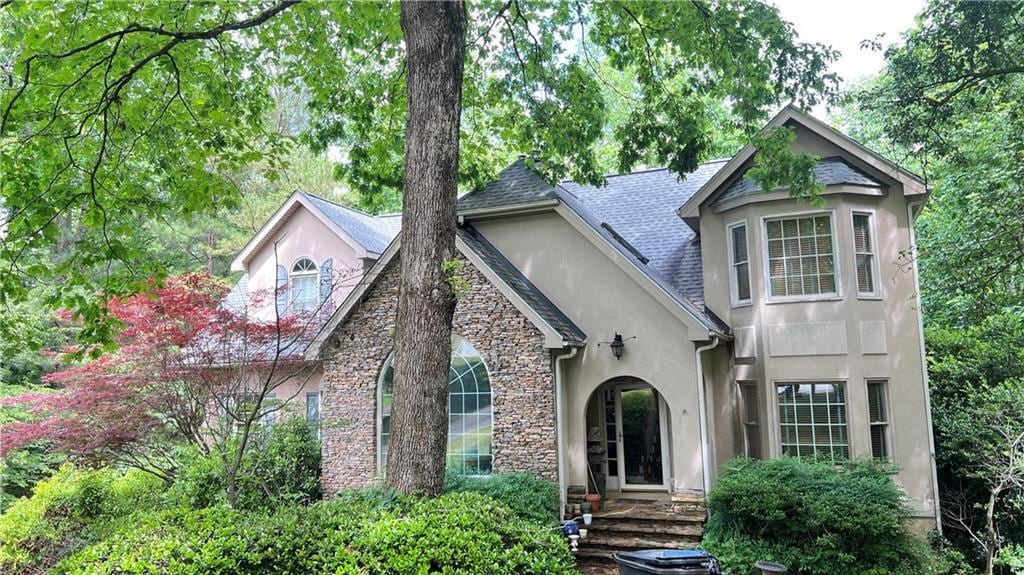 5357 Steeple Chase, Douglasville, GA 30135 - view of front of home with stucco siding, a shingled roof, and stone siding