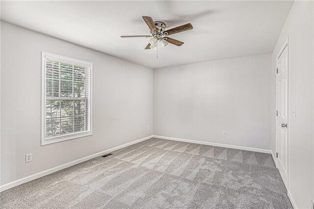 empty room featuring baseboards, carpet floors, and a ceiling fan