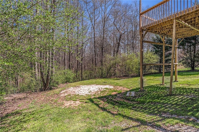 view of yard featuring a view of trees and a deck