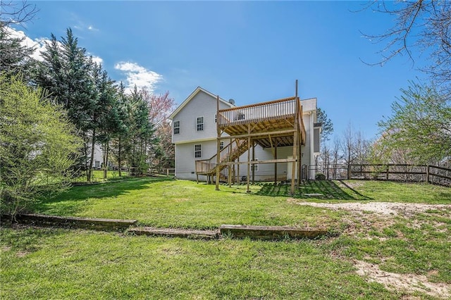 rear view of house featuring fence, a wooden deck, stairway, and a yard