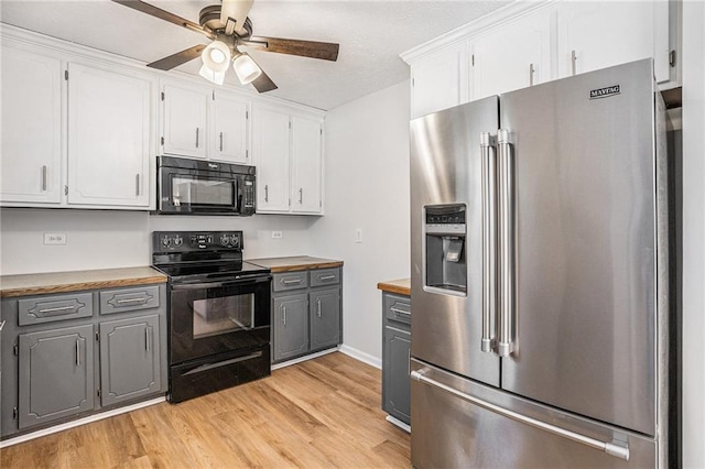 kitchen with a ceiling fan, white cabinetry, light wood-style floors, black appliances, and gray cabinets