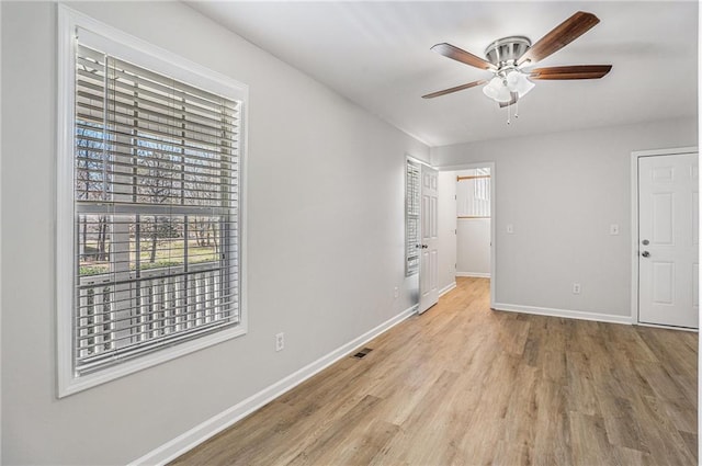 unfurnished bedroom with baseboards, visible vents, wood finished floors, and ceiling fan