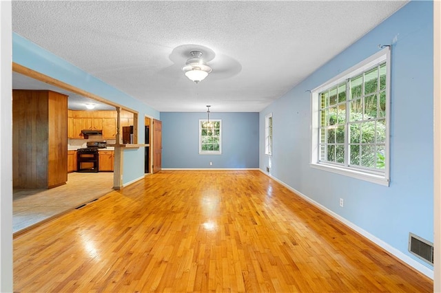 300 S Dale Ave, Calhoun, GA 30701 - unfurnished living room with light wood-style floors, a ceiling fan, plenty of natural light, and a textured ceiling