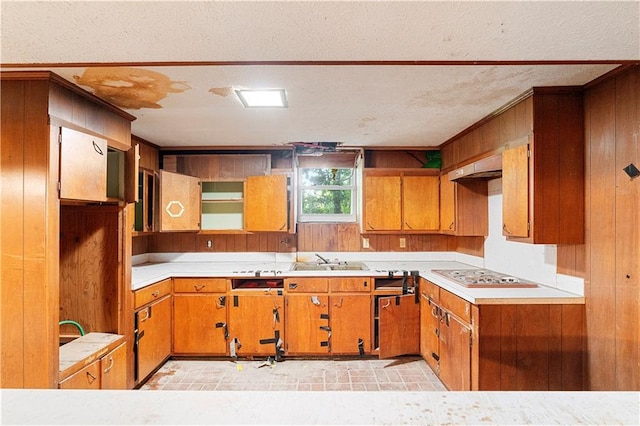 300 S Dale Ave, Calhoun, GA 30701 - kitchen featuring cooktop, brown cabinets, light countertops, wood walls, and a textured ceiling
