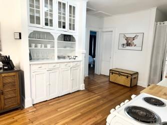 interior space featuring white cabinets, white range oven, and light hardwood / wood-style flooring