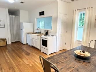 kitchen with hardwood / wood-style floors, white appliances, white cabinetry, and sink